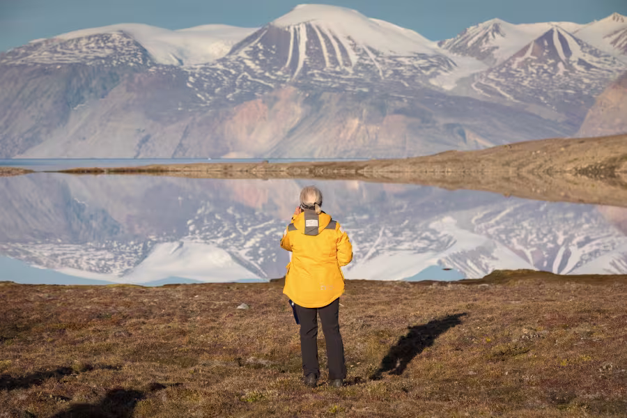 female_pax_alone_in_reflection_landscape_ella_island_east_greenland_